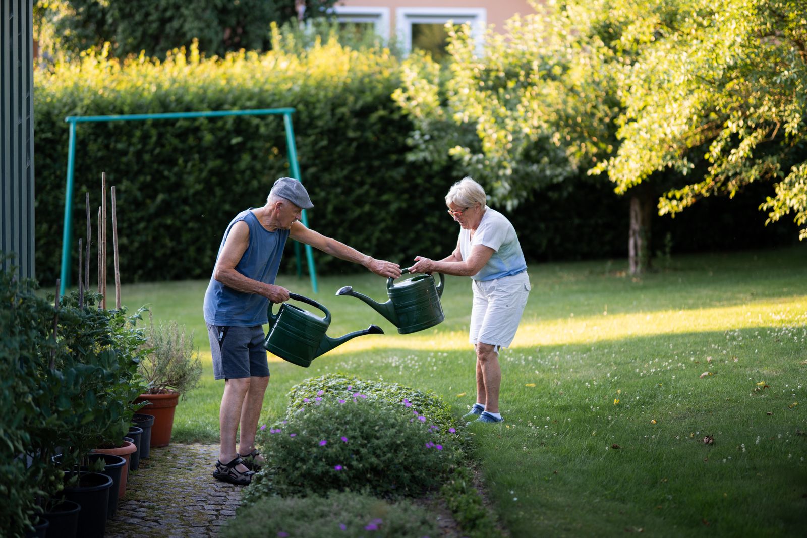 Älteres Paar genießt gemeinsam seinen gepflegten Garten am Abend